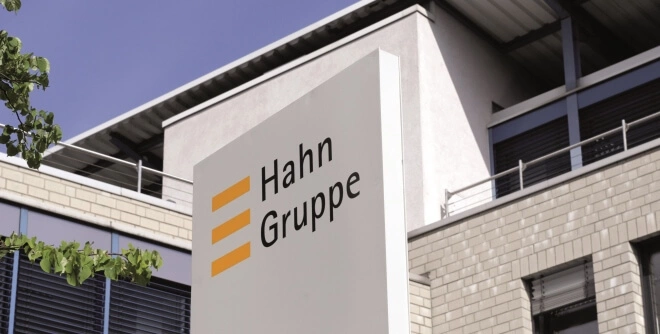 Referenzkunde Hahn Gruppe - Logo vor Firmengebäude
